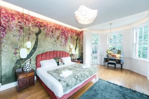 um quarto com uma cama e uma parede floral em The West Wing at Hillthorpe Manor by Maison Parfaite - Large 5 Bedroom House with Gardens em East Hardwick