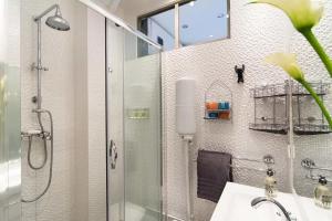 baño con ducha y lavabo con puerta de cristal en My Nest Inn Paris Mouffetard - 30m2 - 200m du jardin des Plantes, en París