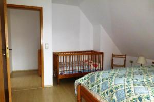 FeWo Ostseerose - DHH 4 في بريرو: غرفة نوم فيها سرير وسرير أطفال