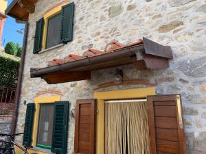 a stone building with green shutters and a door at Deliziosa Casetta Sull'Appennino Toscano in Montefegatesi