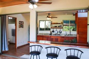 a kitchen with a counter and chairs in a room at Casita Colibri–Mile to the Beach–Cable&Fiber Wifi! in Uvita
