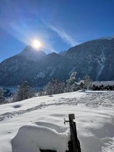 einen schneebedeckten Berg mit der Sonne im Hintergrund in der Unterkunft Raimund Mrak Dependance in Längenfeld