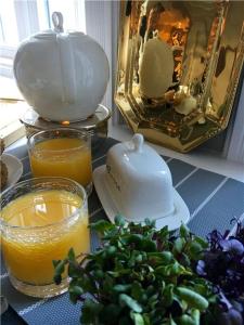 a table with a teapot and a tea pot and orange juice at Stutenhof-EG-Wohnung-3 in Keitum