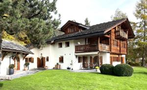 a house with a large yard in front of it at Chalet Mira Golf in Sagogn