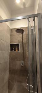 La salle de bains est pourvue d'une douche avec une porte en verre. dans l'établissement DimoraNOIDUE, à Locorotondo