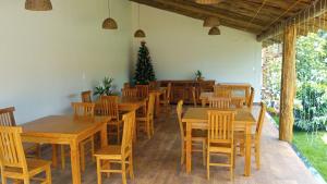 un restaurante con mesas y sillas de madera y un árbol de Navidad en Pousada São José na Canastra, en Delfinópolis