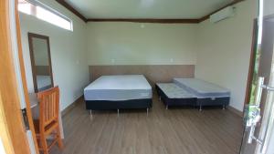Zimmer mit 2 Betten und einem Spiegel in der Unterkunft Pousada São José na Canastra in Delfinópolis