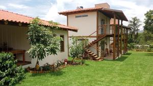 una casa con un patio verde con un edificio en Pousada São José na Canastra en Delfinópolis