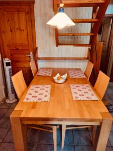 una mesa de madera con sillas y un plato de comida. en Extertal-Ferienpark - Premium Ferienhaus Sonnental - Sauna #50, en Extertal