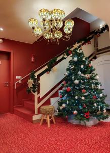 Un árbol de Navidad en una habitación con una escalera en Hôtel Restaurant Le Kastelberg, The Originals Boutique, en Andlau