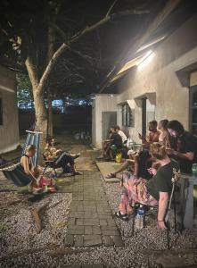 eine Gruppe von Personen, die außerhalb eines Gebäudes sitzen in der Unterkunft Boxpackers Langkawi in Pantai Cenang