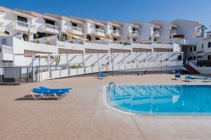 a large apartment building with a swimming pool in front of it at Magnifico chalet en Chayofa in Chayofa