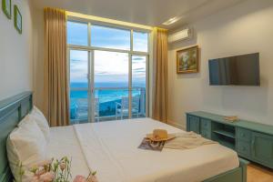 um quarto com uma cama e vista para o oceano em Casa Home - Ocean Melody - Beach Front 3br Apartment em Phan Thiet