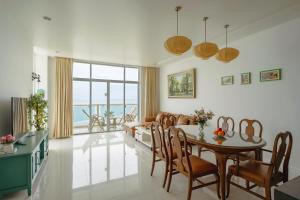 ein Wohnzimmer mit einem Tisch, Stühlen und einem Sofa in der Unterkunft Casa Home - Ocean Melody - Beach Front 3br Apartment in Phan Thiet