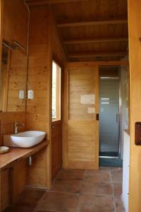 baño con lavabo en una pared de madera en Casa ecológica en plena naturaleza, en Arboli