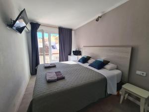 a bedroom with a large bed with towels on it at Amena Mar Hotel in Sa Coma