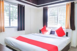 a bedroom with a large bed with red pillows at The Guest house in Pune