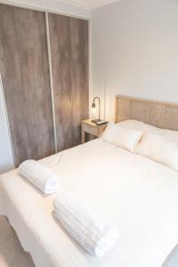 a white bed with two pillows on top of it at Torre Alem 2 A in San Miguel de Tucumán