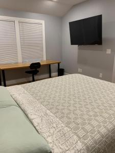a bedroom with a bed and a desk and a television at RobbinsStreetWaltham in Waltham