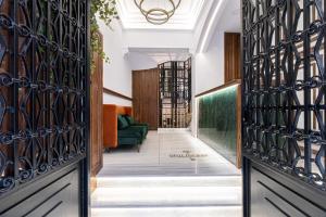 a hallway with wrought iron doors and a green couch at Belle Epoque Suites in Athens