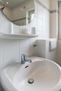 Baño blanco con lavabo y espejo en Haus-Jule, en Tinnum