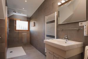 een badkamer met een wastafel en een spiegel bij Alpenvilla Large Family Apartment - by Familiaris- Pools 500 meters in Valdaora +20 foto's