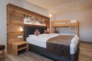 a bedroom with two beds and a bunk bed at Alpenvilla Winklwiese in Valdaora