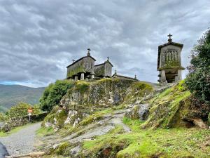 a church on a hill with a cross on it at Casa penedo do bento in Soajo