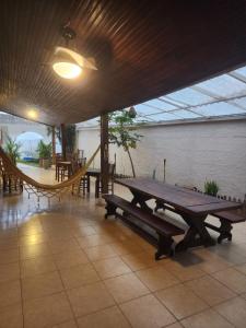 a patio with a picnic table and a hammock at Guaiuba's House in Guarujá