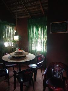 a dining room with a table and chairs and green curtains at Lucky Holiday Home in Anuradhapura