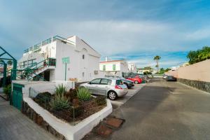 un estacionamiento con autos estacionados frente a un edificio en Blue Ski 6 by Homestaygrancanaria en San Bartolomé