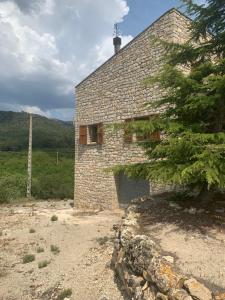 a stone building with a garage in a field at Casa Major in Mont-ral