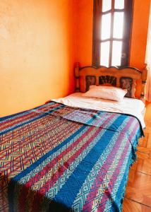 San Rafael的住宿－Hotel IntyKucha，一张床上,床上有五颜六色的被子