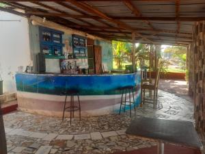 a bar in a building with stools in a room at Smile Gambia Beach Bar in Brufut