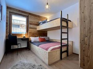 een slaapkamer met een stapelbed en een bureau bij Loges Blanches - APT B404 -BO Immobilier in Châtel
