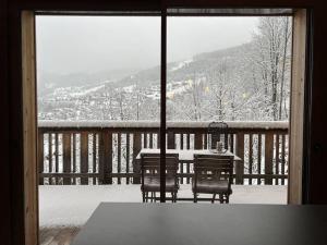 een tafel en stoelen op een veranda in de sneeuw bij Loges Blanches - APT B404 -BO Immobilier in Châtel
