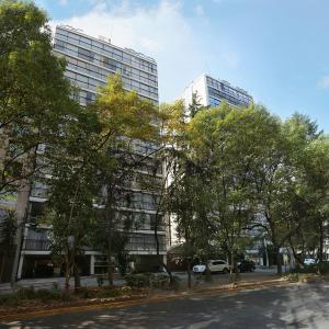 a street in front of two tall buildings with trees at JVM 421, in Polanco by Blueground in Mexico City