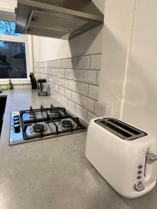 a white toaster sitting next to a stove in a kitchen at Lovely Town house Room 2 in Parkside