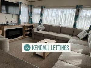 a living room with a couch and a tv at Oakley (West Sands) in Selsey