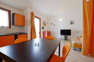 uma cozinha e sala de jantar com mesa e cadeiras em casa vacanza mika em SantʼAnna Arresi