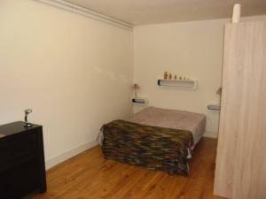 Un dormitorio con una cama en una habitación blanca. en Meublé Bulgarana - 4 pers, en Bourg-Argental