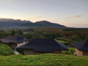 a house on a hill with mountains in the background at Khaolak Blue Sky Villa in Khao Lak