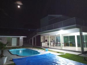 a house with a swimming pool at night at Sitío Paraíso in Jambeiro