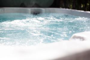 d'une baignoire remplie d'eau bleue et de bulles. dans l'établissement Heron Lodge with Hot-tub, à Carlisle