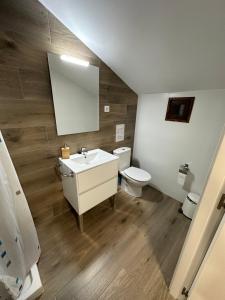 y baño con lavabo, aseo y espejo. en Coll de Port en Tuixen