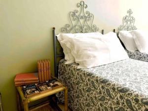 1 dormitorio con cama y mesa auxiliar con almohada en Appartamento Cagliari centro con vista sul porto, en Cagliari