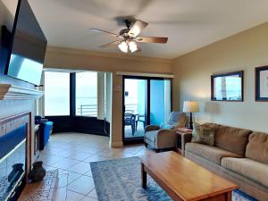 een woonkamer met een bank en een plafondventilator bij Palm Beach Club 113 in Pensacola Beach