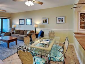 een woonkamer met een tafel en stoelen bij Palm Beach Club 113 in Pensacola Beach