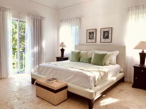 a white bedroom with a large bed and windows at Punta Cana Bay Family Room in Punta Cana