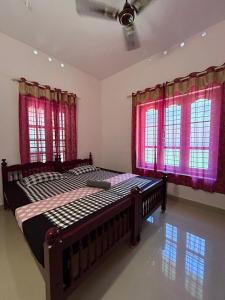 1 dormitorio con 2 camas y ventanas rojas en Kailani boutique stay, en Varkala